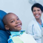 child in dentist chair getting sealants